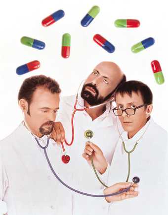 General Idea Playing Doctor 1992 three men dressed as doctors with stethoscopes in their ears listening to each others heart beat there are over sized pills floating above them