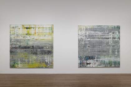 Two square paintings hung side by side on a white wall.