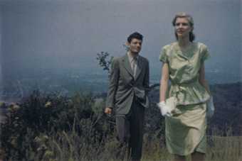 Film still of a man and woman in 1950s clothing on a heath or countryside 