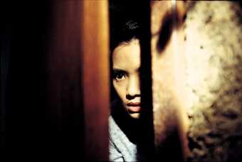 A girl peeks through a doorway