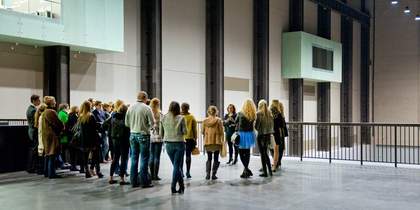 A group of visitors on a guided tour in the Turbine Hall at Tate Modern