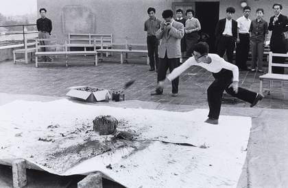 Otsuji Kiyoji documents Shimamoto Shōzō throwing glass bottles of colourful pigments against a stone at the centre of a canvas, 2nd Gutai Exhibition, Tokyo, 1956 