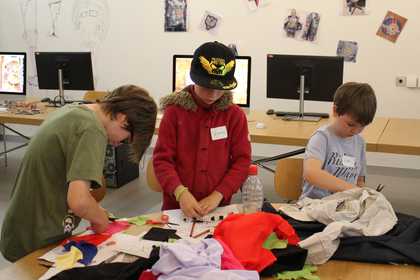 Three young participants make artwork at the Tate Kids handmade digital workshop