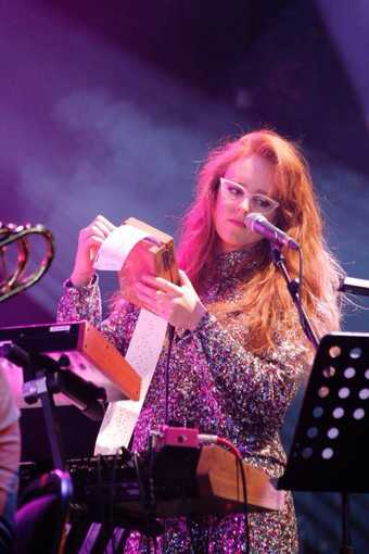 A woman stands with a music box