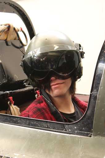 Photograph of someone flying a plane with helmet and goggles.