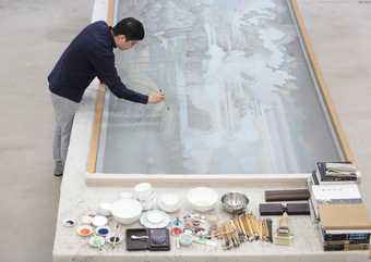 Hao Liang painting in his studio