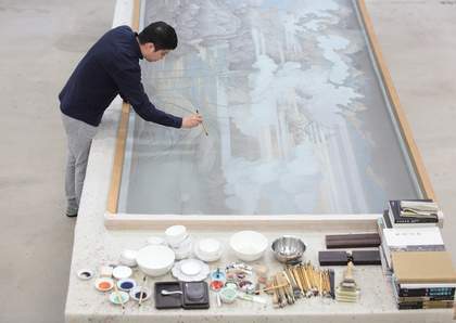 Hao Liang painting in his studio