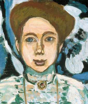 Henri Matisse Portrait of Greta Moll 1908 detail showing a womans head with her brown hair up and a round gold brooche at her throat pinned to her green dress The background is painted blue