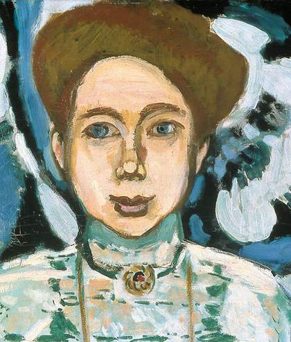 Henri Matisse Portrait of Greta Moll 1908 detail showing a womans head with her brown hair up and a round gold brooche at her throat pinned to her green dress The background is painted blue