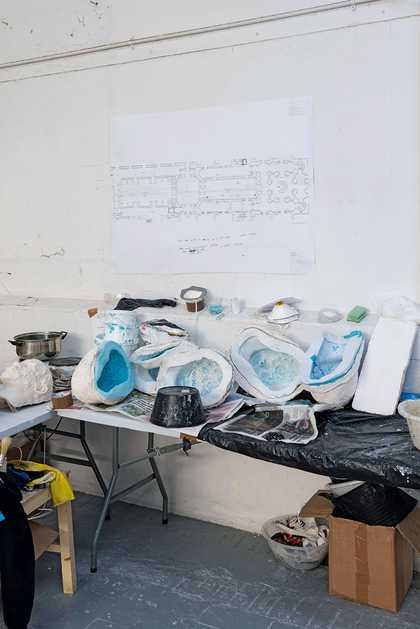 Interior shot showing moulds for masks in Hew Locke's studio