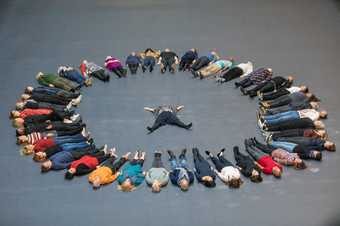 a group of people lay on the floor in a circle