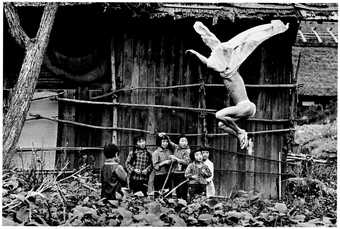 Black and white photograph of man jumping semi naked