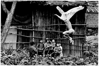Black and white photograph of man jumping semi naked