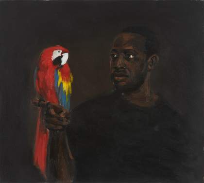 A man holds a parrot in his right hand and looks at the parrot