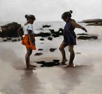 two girls play on the sand on a beach