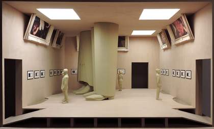 A model of a gallery with two people and two huge legs standing in the middle
