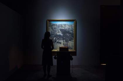 A woman stands with headphones on in front of Francis Bacon’s Figure in a Landscape 1945