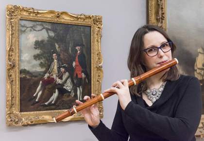 a woman plays the flute in front of in front of Thomas Gainsborough’s Peter Darnell Muilman, Charles Crokatt and William Keable in a Landscape c.1750