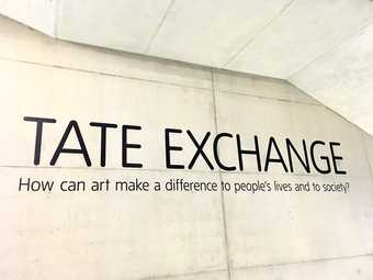 Photograph of text on a wall at Tate Modern reading: TATE EXCHANGE, How can art make a difference to people's lives and to society?