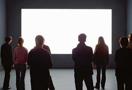 Installation view of Alredo Jaars Lament of the Images 2002 at the Louisiana Museum of Modern Art visitors watching a projection of a white rectangle in a gallery