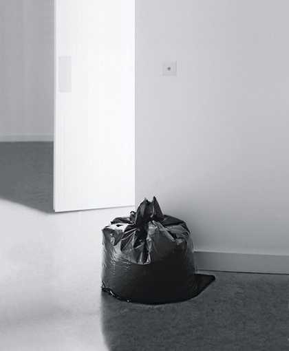 Installation view of Ceal Floyers Garbage Bag at Ikon Gallery Birmingham 2001 photograph of a black bin bag against a white gallery wall