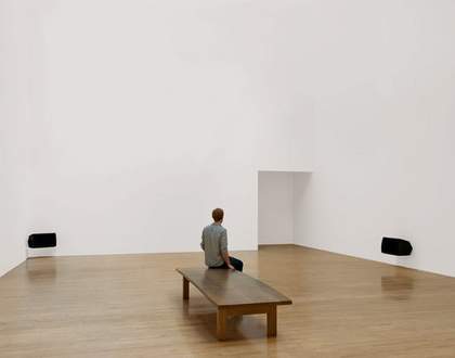 Installation view of Turner Prize winner Susan Philipszs Lowlands at Tate Britain October 2010 photograph of a white gallery with two audio speakers and a visitor sat on a bench