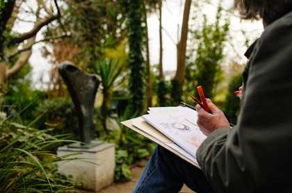Close up of Irene's hand on a sketch she's made in the Barbara Hepworth sculpture garden