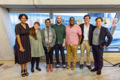 Seven people stand in a group