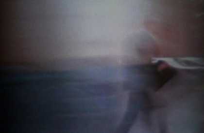 A blurred image of a man holding a newspaper
