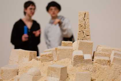 Visitors looking at Kada Attia's sculpture 'Untitled (Ghardaïa)' 2009 in the Living Cities display at Tate Modern