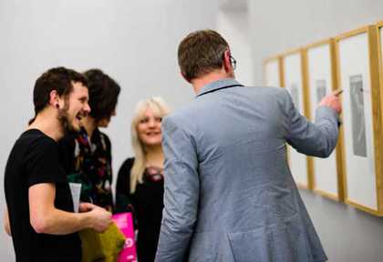 Four visitors in the Tate Liverpool gallery looking at some of the art on display