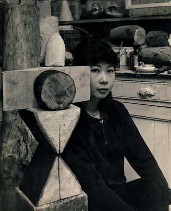 Photograph of artist Kim Lim with her sculpture 'Chess Piece'
