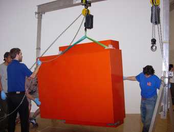 Art Handlers positioning the red box element during installation.