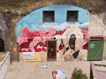 a mural on a rail archway depicting a woman in a field of flowers