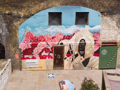 a mural on a rail archway depicting a woman in a field of flowers
