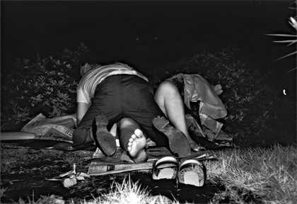 Kohei Yoshiyuki Untitled from the series the park photograph of a man lying on top of a woman amongst bushes