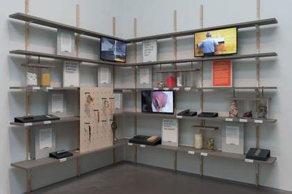 shelves on walls containing paintings and found objects