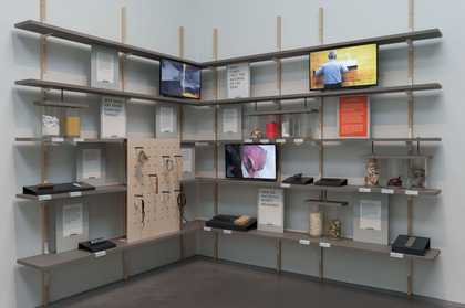 shelves on walls containing paintings and found objects