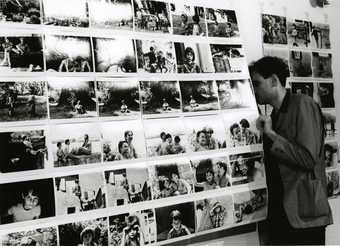 a man looks at black and white photographs on display