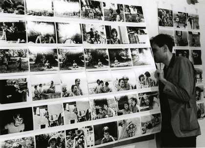 a man looks at black and white photographs on display