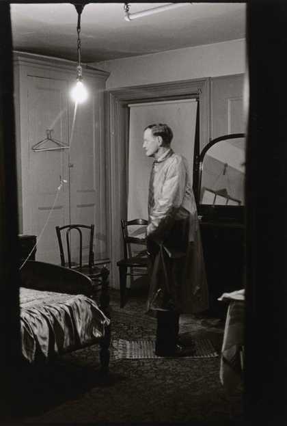 Man standing in a room, his legs are facing backwards but his torso is forwards