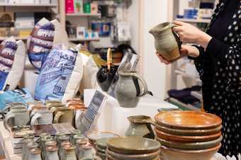 a person holds some pottery in the tate st ives shop