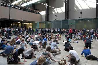 crowd of dancers kneeling and moving around on the floor in turbine hall 