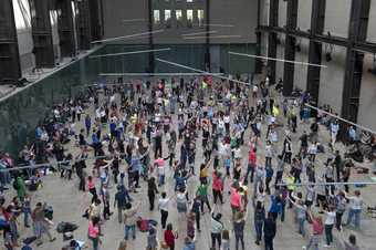 visitors standing and beginning to dance in the turbine hall