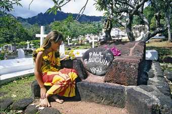 A local girl sitting next to Paul Gauguins grave in Atuona Hiva Oa on the Marquesas Islands French Polynesia