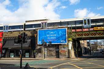 Large billboard at a road junction which reads 'Life Between Islands in Brixton
