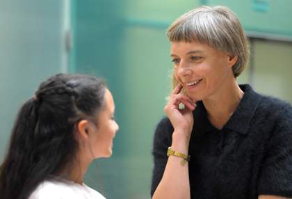 artist Lina Lapelyte leans into speak to a child