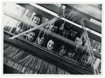 weavers looking through the loom to the camera