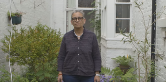 an image of Lubaina Himid standing in front of a house