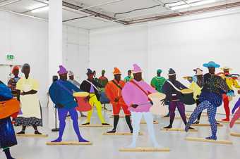 Lubaina Himid 'Naming the Money' 2004 a series of colourful cut out figures are places in a white walled gallery space